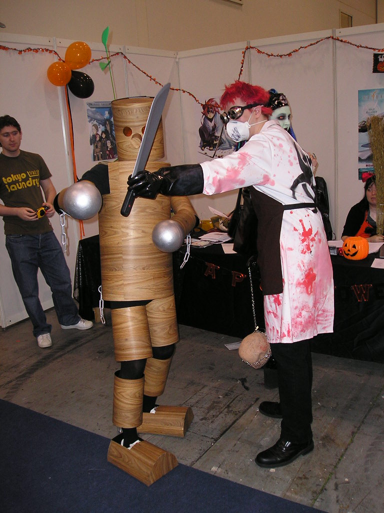 mokujin, mokujin (tekken), londonexpo, tekken, cosplay photo, photo (medium), 2boys, apron, blood, blood on clothes, cosplay, indoors, knife, multiple boys, poster (medium), puppet