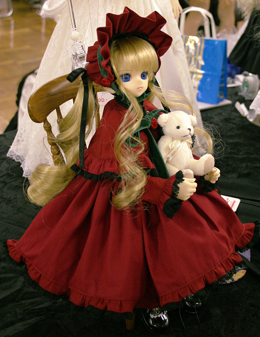 shinku, rozen maiden, photo (medium), 00s, 1girl, blonde hair, blue eyes, curly hair, doll, dress, female focus, long hair, red dress, shawl, solo, stuffed animal, stuffed toy, teddy bear, twintails