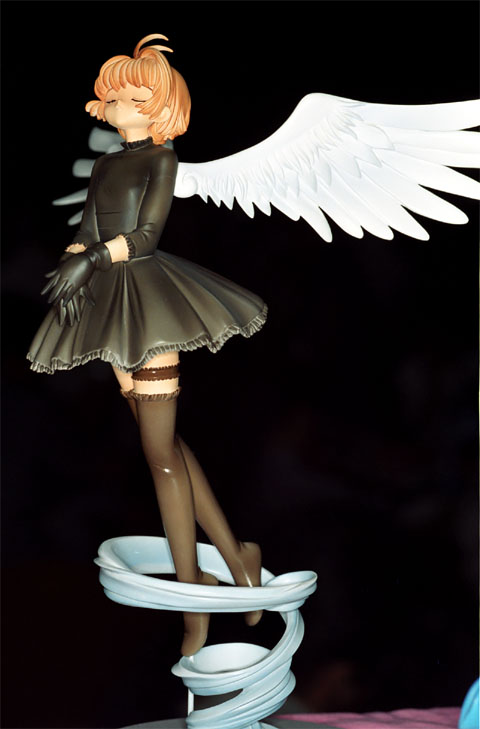 kinomoto sakura, cardcaptor sakura, photo (medium), 1990s (style), 1girl, black dress, black gloves, black theme, black thighhighs, child, dark, dress, female focus, figure, full body, gloves, retro artstyle, solo, thighhighs, wings, zettai ryouiki