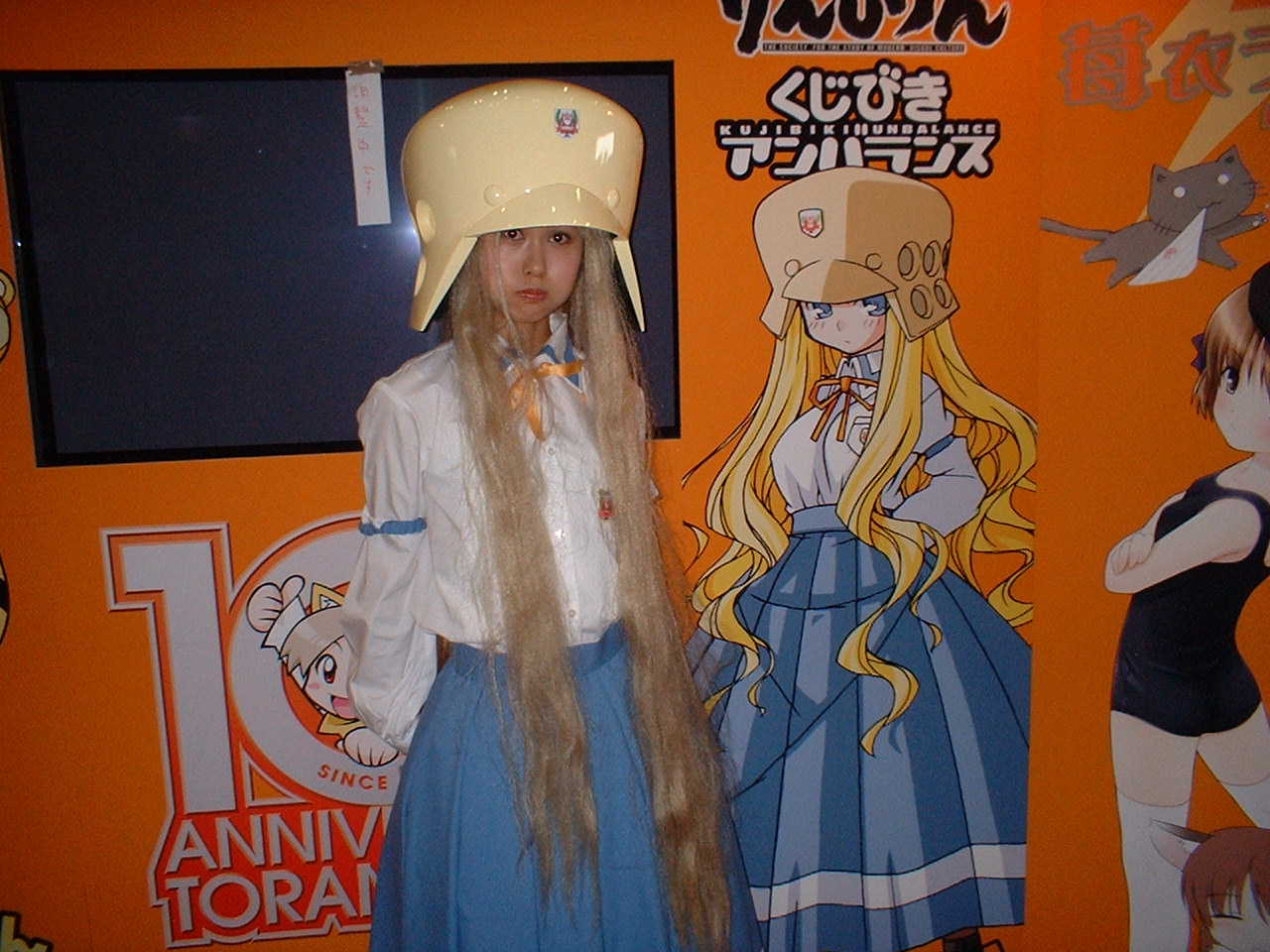 ritsuko kubel kettenkrad, kujibiki unbalance, cosplay photo, photo (medium), 1girl, arm garter, blonde hair, cosplay, long hair, looking at viewer, shirt, standing, very long hair