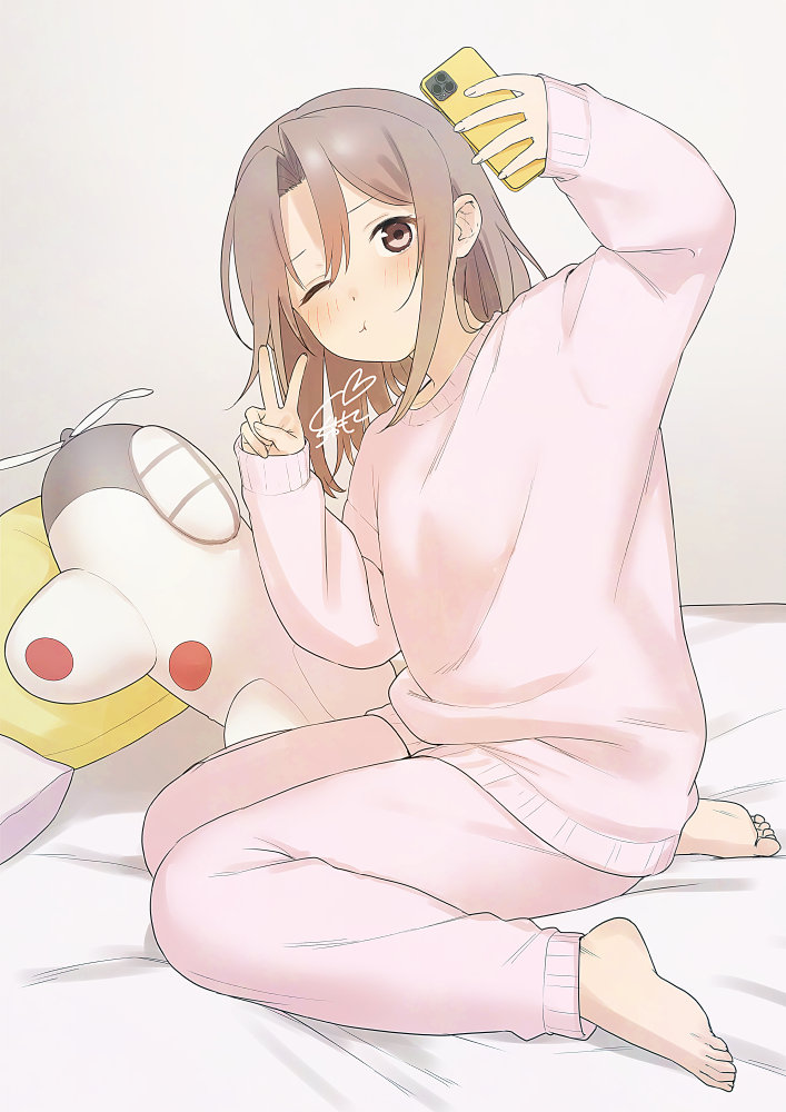 sakiecho, zuihou (kancolle), kantai collection, commentary request, 1girl, :t, alternate costume, arm up, barefoot, bed sheet, blush, brown eyes, brown hair, cellphone, feet, full body, hair between eyes, holding, holding phone, indoors, iphone, long hair, long sleeves, on bed, one eye closed, pajamas, pants, phone, pillow, pink hair, pink pants, sidelocks, sitting, sleeves past wrists, smartphone, solo, stuffed airplane, stuffed toy, taking picture, v, wariza