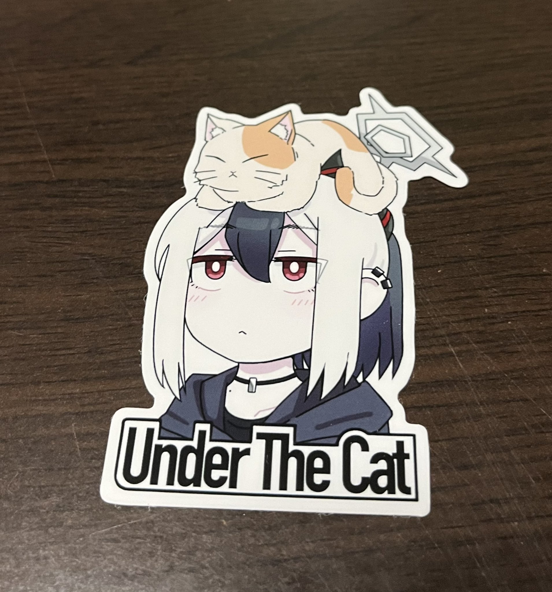 vividnatadecoco, kayoko (blue archive), blue archive, commentary request, highres, photo (medium), 1girl, :<, animal, animal ear fluff, animal on head, black hair, black hoodie, black shirt, blush, cat, closed mouth, collarbone, cropped torso, ear piercing, english text, hood, hood down, hoodie, horns, multicolored hair, on head, piercing, ponytail, red eyes, shirt, solo, sticker (medium), two-tone hair, upper body, white hair