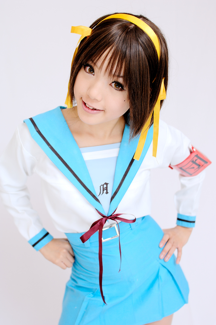 kipi-san, suzumiya haruhi, suzumiya haruhi no yuuutsu, photo (medium), 1girl, armband, asian, brown eyes, brown hair, cosplay, female focus, hair ribbon, looking at viewer, mole, ribbon, school uniform, serafuku, simple background, solo, suzumiya haruhi (cosplay), white background