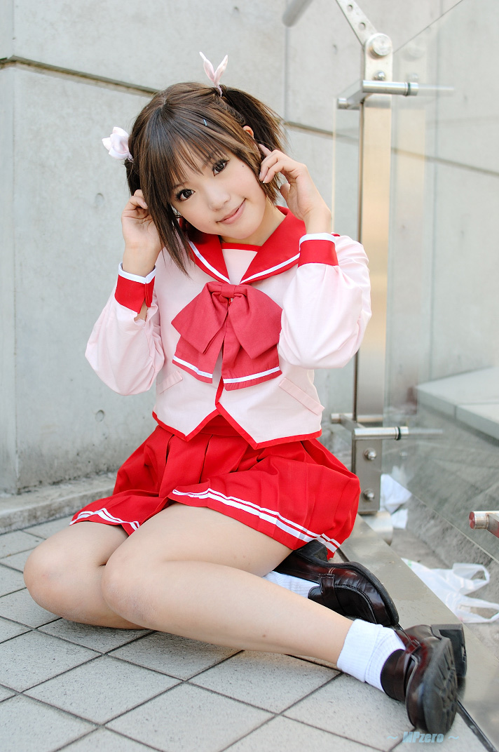 kipi-san, yuzuhara konomi, to heart (series), to heart 2, photo (medium), 1girl, asian, brown hair, cosplay, female focus, looking at viewer, mole, outdoors, school uniform, serafuku, short hair, sitting, smile, socks, solo, twintails, yokozuwari, yuzuhara konomi (cosplay)