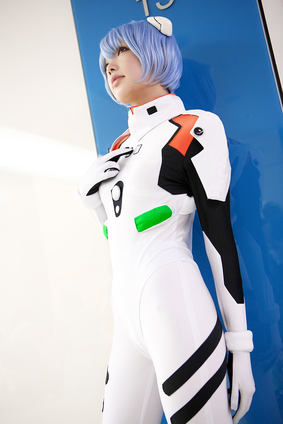 namada, ayanami rei, neon genesis evangelion, highres, photo (medium), 1girl, asian, blue hair, color contacts, cosplay, cowboy shot, dutch angle, female focus, hairpods, mecha pilot suit, parted lips, plugsuit (evangelion), red eyes, short hair, solo, standing