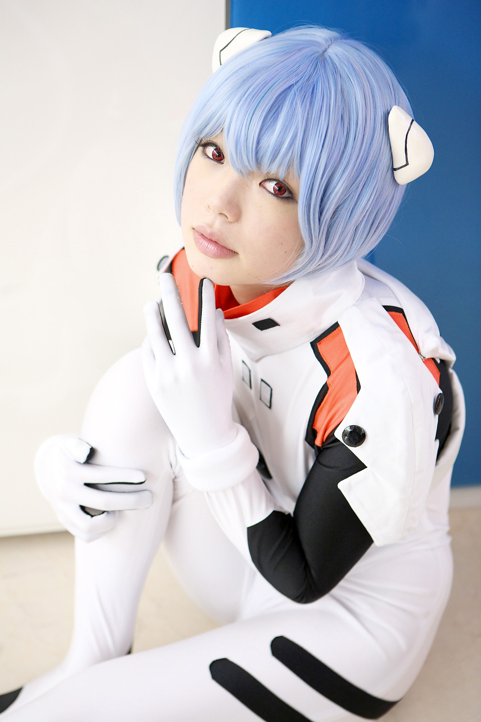 namada, ayanami rei, neon genesis evangelion, highres, photo (medium), 1girl, asian, blue hair, color contacts, cosplay, female focus, hairpods, looking at viewer, mecha pilot suit, plugsuit (cosplay), plugsuit (evangelion), red eyes, short hair, sitting, solo
