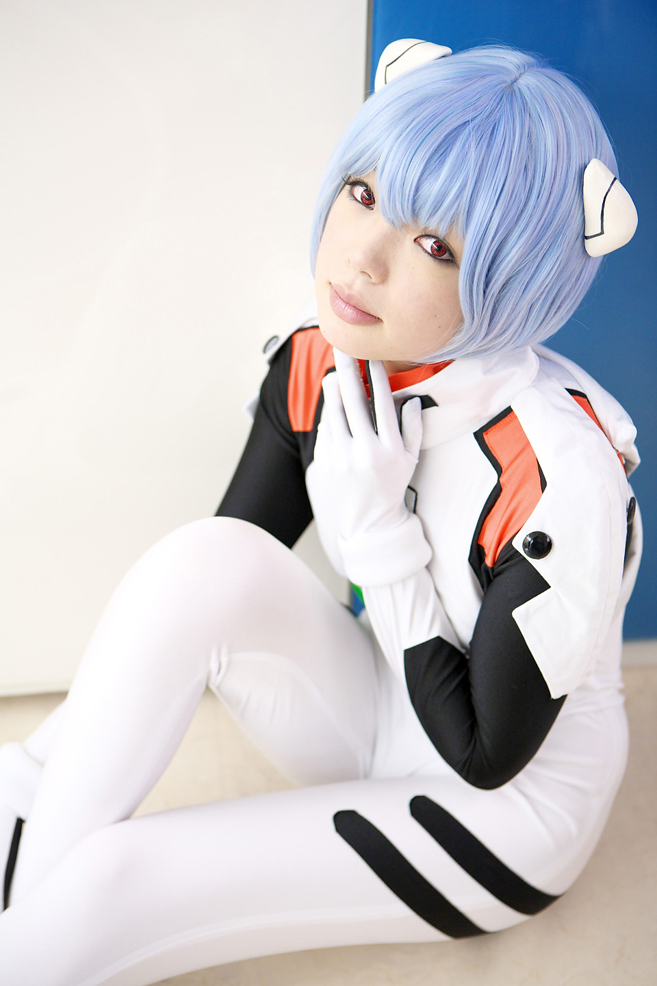 namada, ayanami rei, neon genesis evangelion, highres, photo (medium), 1girl, asian, blue hair, color contacts, cosplay, female focus, hairpods, looking at viewer, mecha pilot suit, parted lips, plugsuit (cosplay), plugsuit (evangelion), red eyes, short hair, sitting, solo