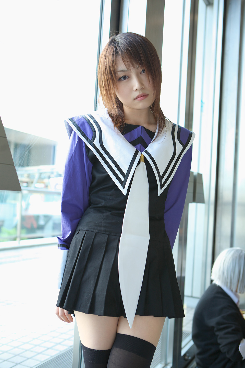 yoshizuki iori, i"s, highres, photo (medium), 1girl, brown eyes, brown hair, cosplay, dutch angle, indoors, looking at viewer, school uniform, serafuku, thighhighs, zettai ryouiki