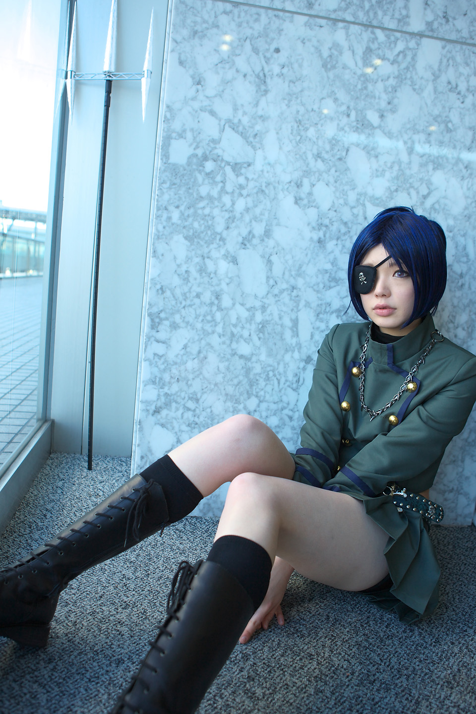 namada, chrome dokuro, katekyo hitman reborn!, highres, photo (medium), 1girl, asian, black socks, blue hair, blurry, boots, breasts, color contacts, cosplay, depth of field, eyepatch, female focus, indoors, lace-up boots, looking afar, makeup, mascara, midriff, miniskirt, on floor, parted lips, pleated skirt, polearm, rug, short hair, sitting, skirt, skull and crossbones, skull belt, small breasts, socks, solo, trident, weapon