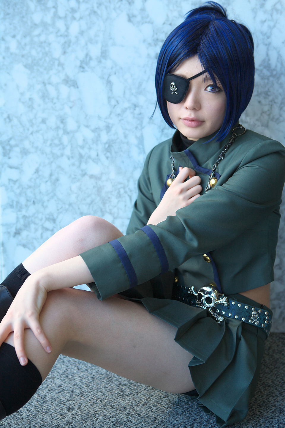 namada, chrome dokuro, katekyo hitman reborn!, highres, photo (medium), 1girl, asian, black socks, blue hair, boots, breasts, color contacts, cosplay, eyepatch, female focus, looking at viewer, makeup, mascara, midriff, miniskirt, on floor, pleated skirt, rug, short hair, sitting, skirt, skull and crossbones, skull belt, small breasts, socks, solo