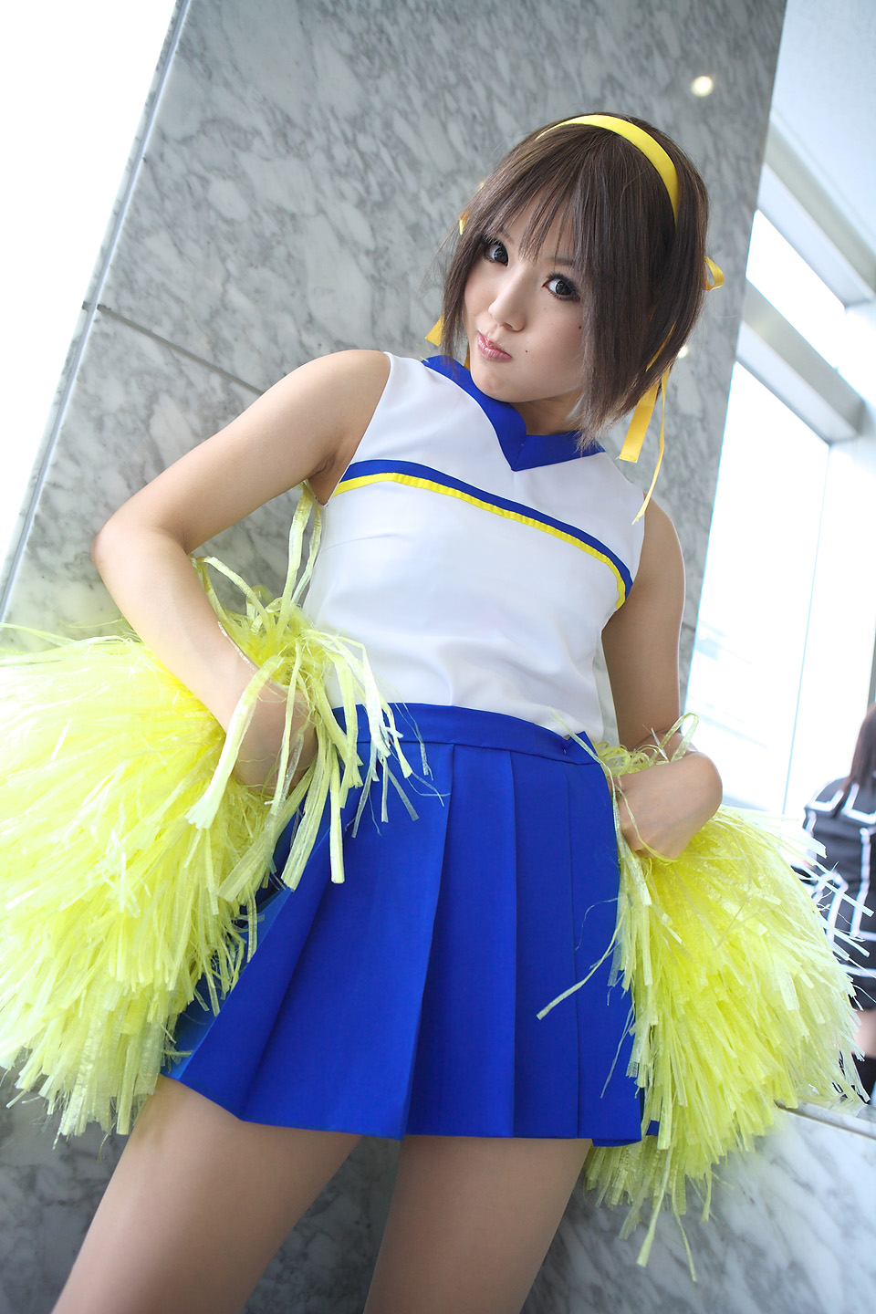 kipi-san, suzumiya haruhi, suzumiya haruhi no yuuutsu, highres, photo (medium), 1girl, :t, asian, brown eyes, brown hair, cheerleader, cosplay, female focus, looking at viewer, mole, pom pom (cheerleading), smile, solo, suzumiya haruhi (cosplay)