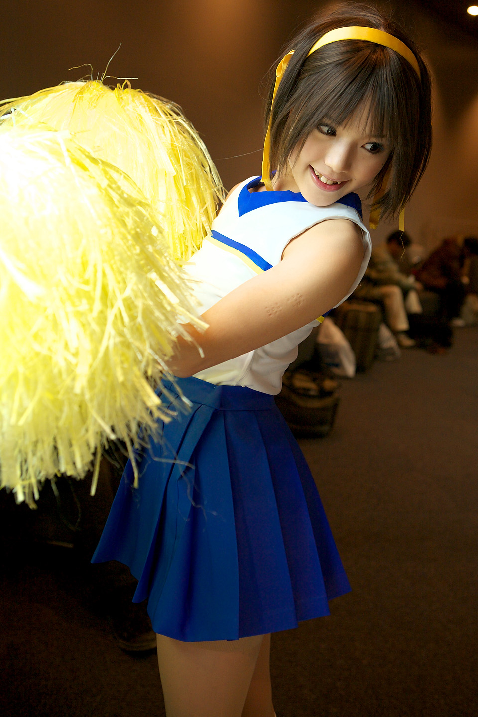 kipi-san, suzumiya haruhi, suzumiya haruhi no yuuutsu, highres, photo (medium), 1girl, asian, brown eyes, brown hair, cheerleader, cosplay, female focus, indoors, mole, pom pom (cheerleading), smile, solo, suzumiya haruhi (cosplay)