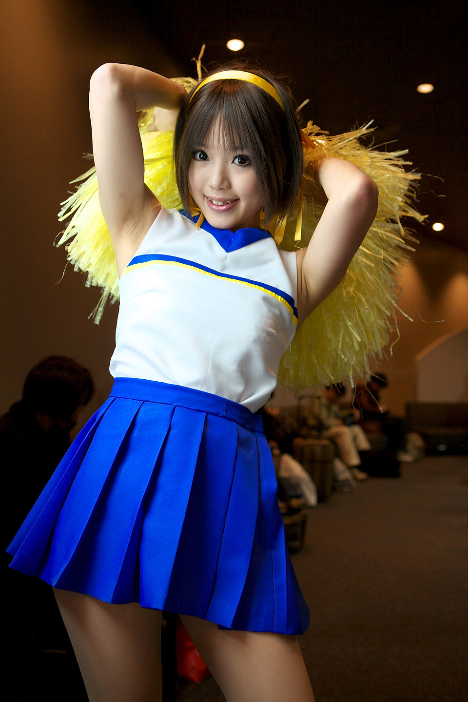 kipi-san, suzumiya haruhi, suzumiya haruhi no yuuutsu, highres, photo (medium), 1girl, asian, brown eyes, brown hair, cheerleader, cosplay, female focus, indoors, looking at viewer, mole, pom pom (cheerleading), smile, solo, suzumiya haruhi (cosplay)