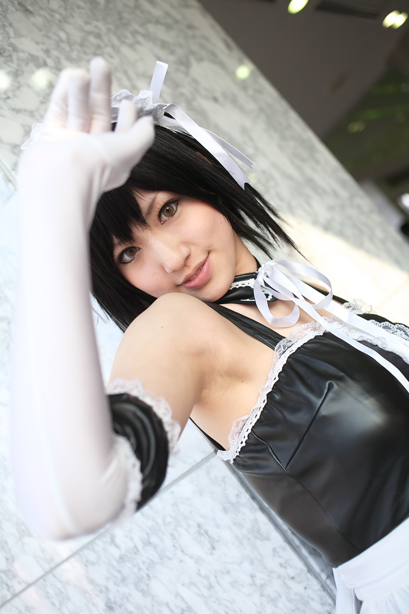 saya (cosplayer), sawatari izumi, kore ga watashi no goshujin-sama, highres, photo (medium), 1girl, apron, armpits, asian, bare shoulders, black hair, blurry, cosplay, cowboy shot, depth of field, detached collar, dutch angle, elbow gloves, facing viewer, female focus, finger to mouth, garter straps, gloves, indoors, japanese (nationality), looking at viewer, maid, maid apron, maid headdress, makeup, mascara, nakabayashi yoshitaka's maid uniform, sawatari izumi (cosplay), short hair, solo, standing, upper body, waist apron, white apron, white gloves