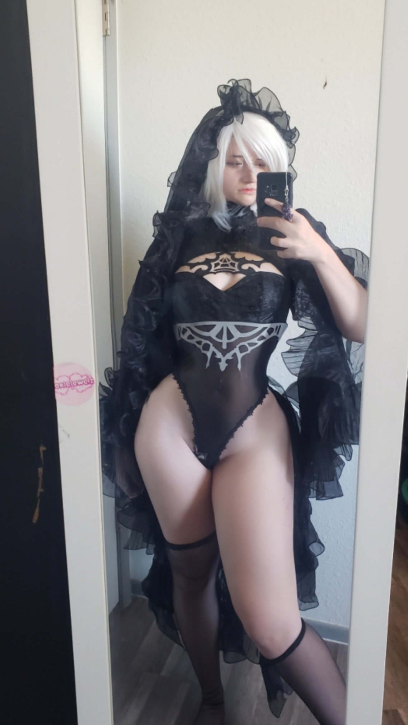 unkyndled, 2b (nier:automata), nier:automata, nier (series), real life, 1girl, 2b (nier:automata) (cosplay), black gloves, black hairband, black leotard, black thighhighs, breasts, bridal veil, cosplay, covered navel, elbow gloves, frilled leotard, frills, gloves, hairband, highleg, highleg leotard, holding, holding phone, leotard, narrow waist, phone, selfie, short hair, thighhighs, thong leotard, veil, white hair