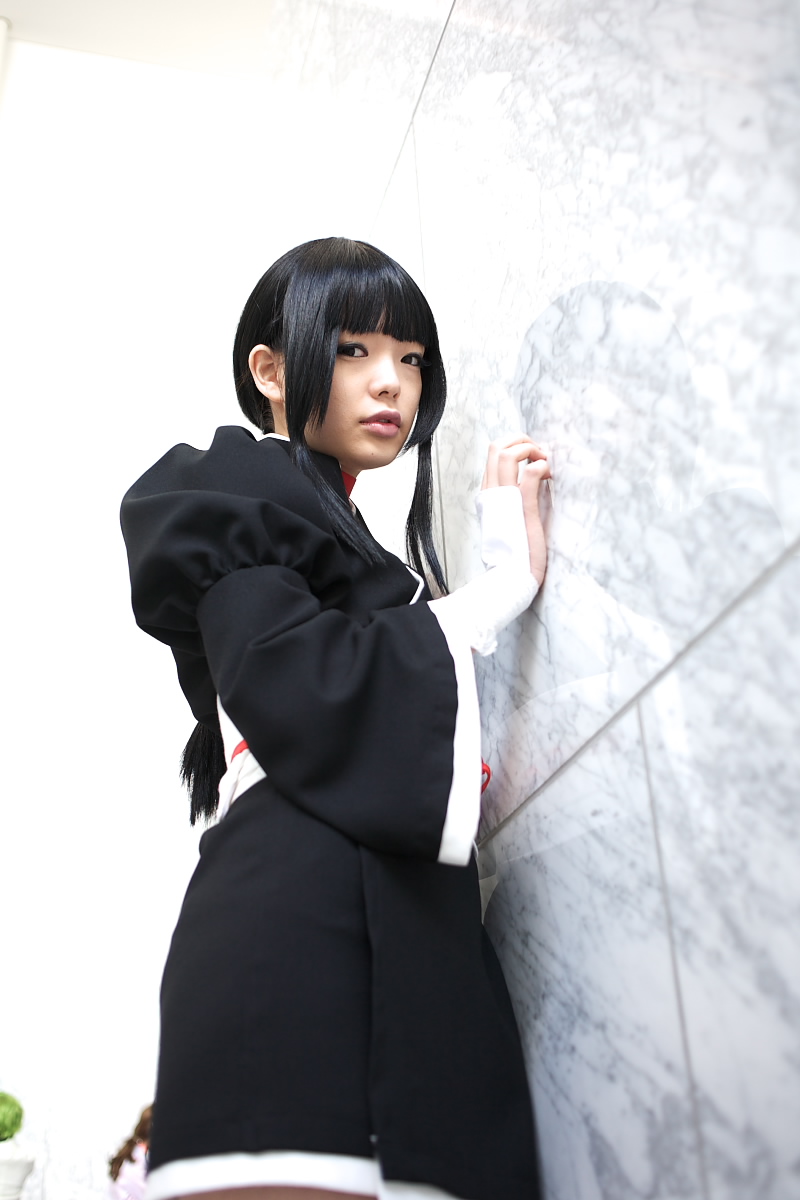 namada, kurotsuchi nemu, bleach, highres, photo (medium), 1girl, against wall, asian, black hair, black kimono, blunt bangs, blurry, breasts, choker, cosplay, cowboy shot, depth of field, eyeshadow, female focus, from below, indoors, japanese clothes, kimono, looking at viewer, makeup, mascara, parted lips, puffy sleeves, reflection, short kimono, sidelocks, small breasts, solo, standing, wide sleeves