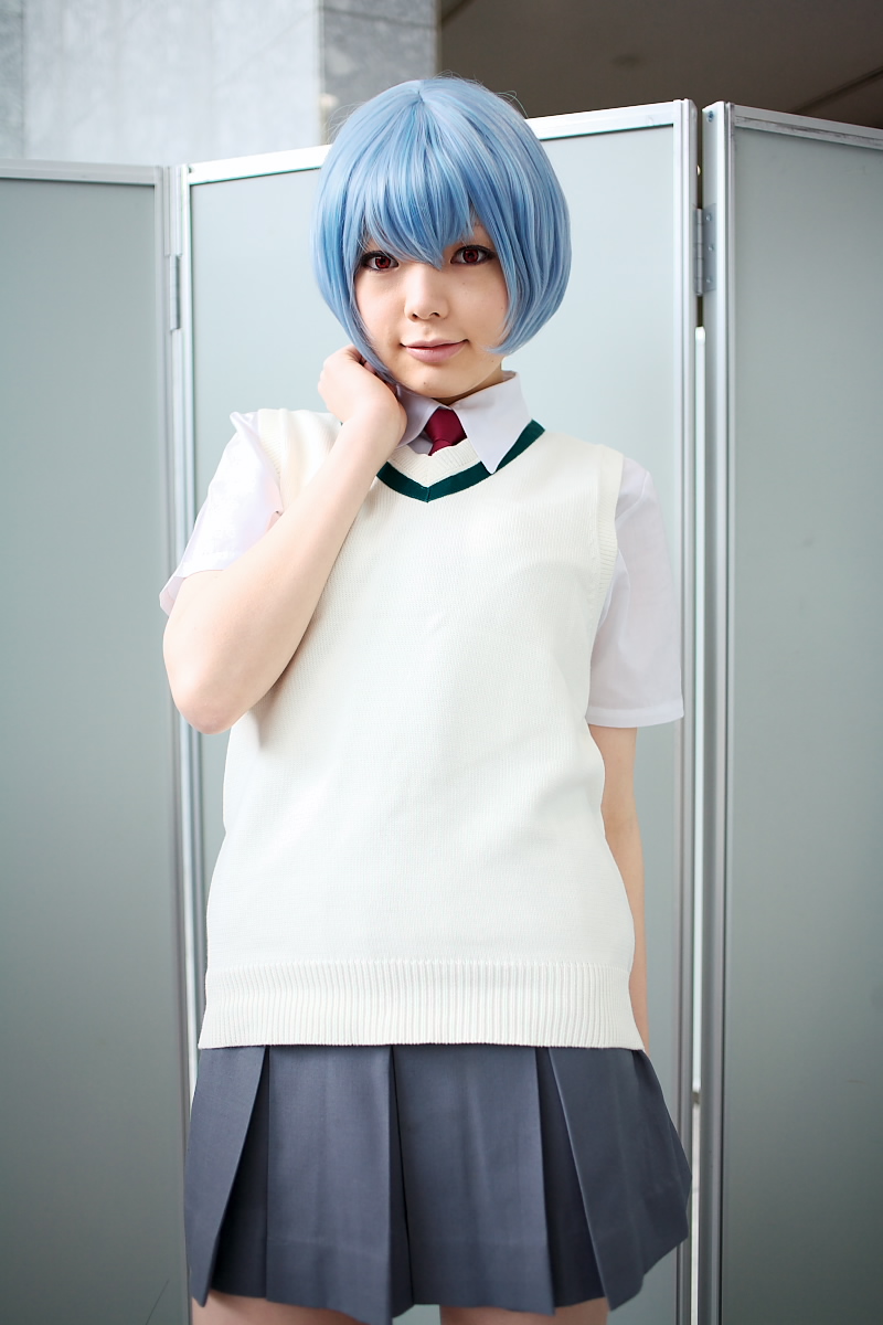 namada, ayanami rei, neon genesis evangelion, highres, photo (medium), 1girl, alternate costume, asian, blue hair, breasts, color contacts, cosplay, female focus, grey skirt, indoors, looking at viewer, miniskirt, necktie, pleated skirt, red eyes, red necktie, school uniform, shirt, short hair, short sleeves, skirt, small breasts, socks, solo, standing, sweater vest, white shirt