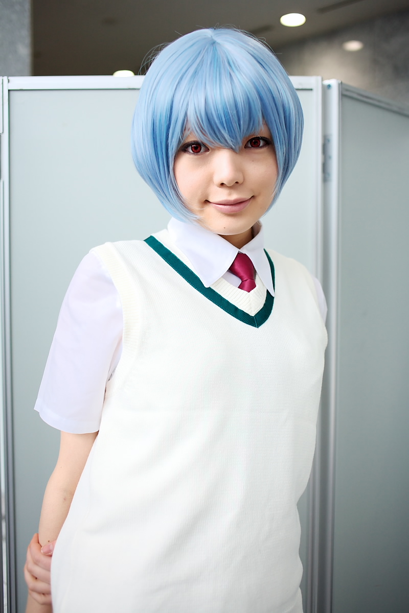 namada, ayanami rei, neon genesis evangelion, highres, photo (medium), 1girl, alternate costume, asian, blue hair, breasts, color contacts, cosplay, female focus, indoors, looking at viewer, necktie, red eyes, red necktie, school uniform, shirt, short hair, short sleeves, skirt, small breasts, smile, solo, standing, sweater vest, white shirt