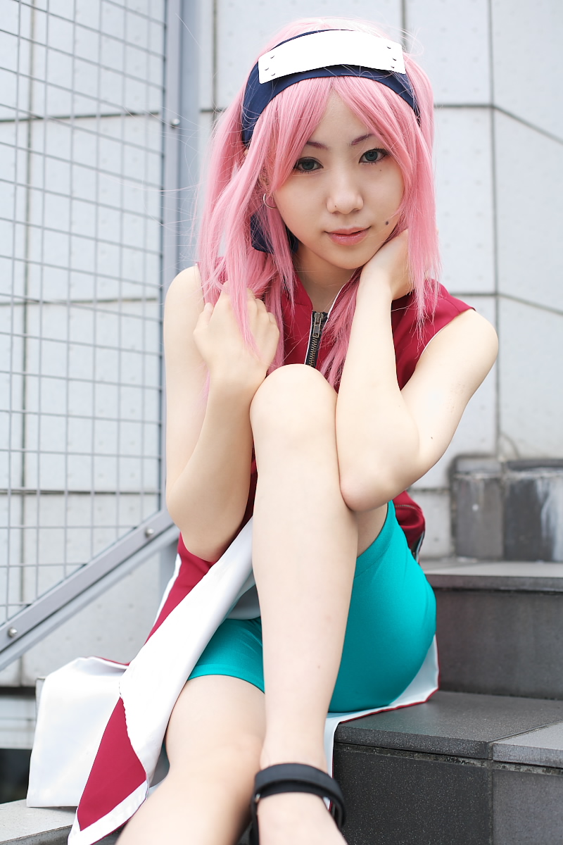 haruno sakura, naruto (classic), naruto (series), real life, highres, photo (medium), 1girl, asian, bare shoulders, bike shorts, black eyes, cosplay, dress, earrings, female focus, haruno sakura (cosplay), headband, headdress, jewelry, lips, looking at viewer, mole, outdoors, pink hair, red dress, short hair, shorts, sleeveless, sleeveless dress, solo, stairs, zipper