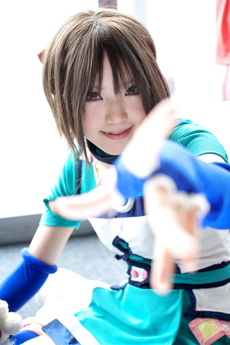 kipi-san, mel, gensou suikoden, gensou suikoden iii, blue legwear, highres, photo (medium), 1girl, asian, blue gloves, blurry, breasts, brown eyes, brown hair, cosplay, depth of field, elbow gloves, fingerless gloves, gloves, indoors, looking at viewer, mel (cosplay), mole, outstretched arm, short hair, small breasts, smile