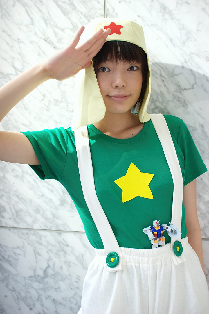 namada, keroro, gundam, keroro gunsou, photo (medium), 1girl, action figure, asian, black hair, breasts, cosplay, female focus, green shirt, gunpla, keroro (cosplay), looking at viewer, model kit, mole, salute, shirt, short sleeves, small breasts, solo, standing, star (symbol), suspenders, t-shirt, toy