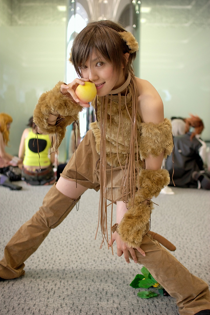 namako, tm revolution, wild rush, fur, photo (medium), 1girl, animal ears, asian, blurry, brown eyes, brown hair, choker, cosplay, depth of field, dog ears, fake animal ears, food, fringe trim, fruit, grapes, indoors, leaf, leaning forward, looking at viewer, matching hair/eyes, outstretched arm, peach, short hair, smile, solo focus, thighhighs