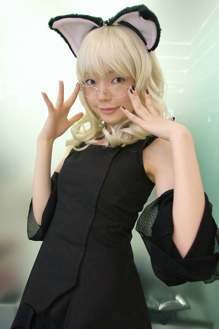 namada, elfriede, tsukuyomi moonphase, photo (medium), 1girl, animal ears, asian, bare shoulders, black dress, black nails, blonde hair, breasts, brown eyes, cat ears, cosplay, detached sleeves, dress, elfriede (cosplay), fake animal ears, female focus, glasses, indoors, long hair, looking at viewer, looking over eyewear, nail polish, rimless eyewear, small breasts, solo, standing
