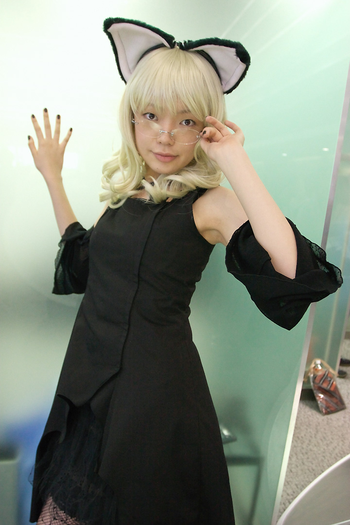 namada, elfriede, tsukuyomi moonphase, fishnet legwear, photo (medium), 1girl, animal ears, asian, bare shoulders, black dress, black nails, blonde hair, breasts, brown eyes, cat ears, cosplay, detached sleeves, dress, dutch angle, elfriede (cosplay), fake animal ears, female focus, fishnets, glasses, indoors, long hair, looking at viewer, looking over eyewear, nail polish, rimless eyewear, small breasts, solo, standing