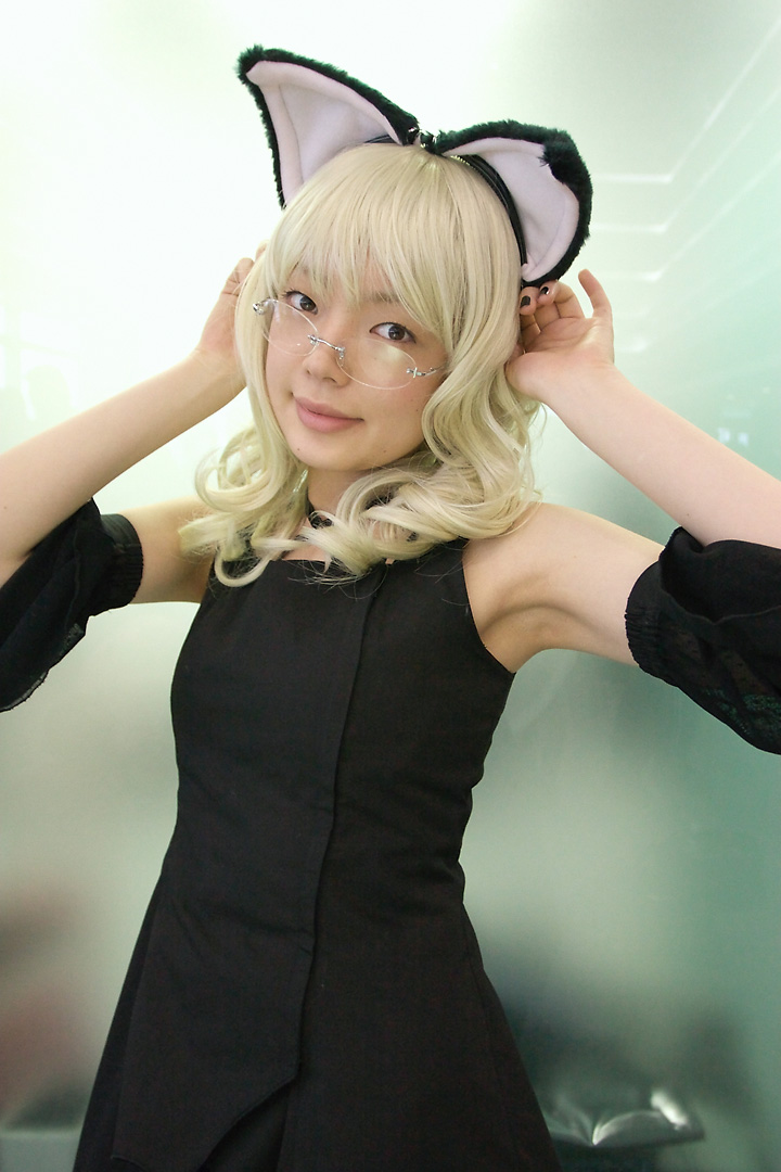 namada, elfriede, tsukuyomi moonphase, photo (medium), 1girl, animal ears, armpits, asian, bare shoulders, black dress, black nails, blonde hair, breasts, cat ears, cosplay, detached sleeves, dress, elfriede (cosplay), fake animal ears, female focus, glass wall, glasses, long hair, looking at viewer, looking over eyewear, mole, nail polish, reflection, rimless eyewear, small breasts, solo, standing, upper body