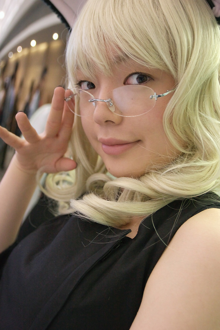 namada, elfriede, tsukuyomi moonphase, photo (medium), 1girl, animal ears, asian, bare shoulders, black dress, blonde hair, blurry, breasts, cat ears, cosplay, depth of field, detached sleeves, dress, elfriede (cosplay), fake animal ears, female focus, glasses, long hair, looking at viewer, looking over eyewear, mole, rimless eyewear, small breasts, solo, standing, upper body