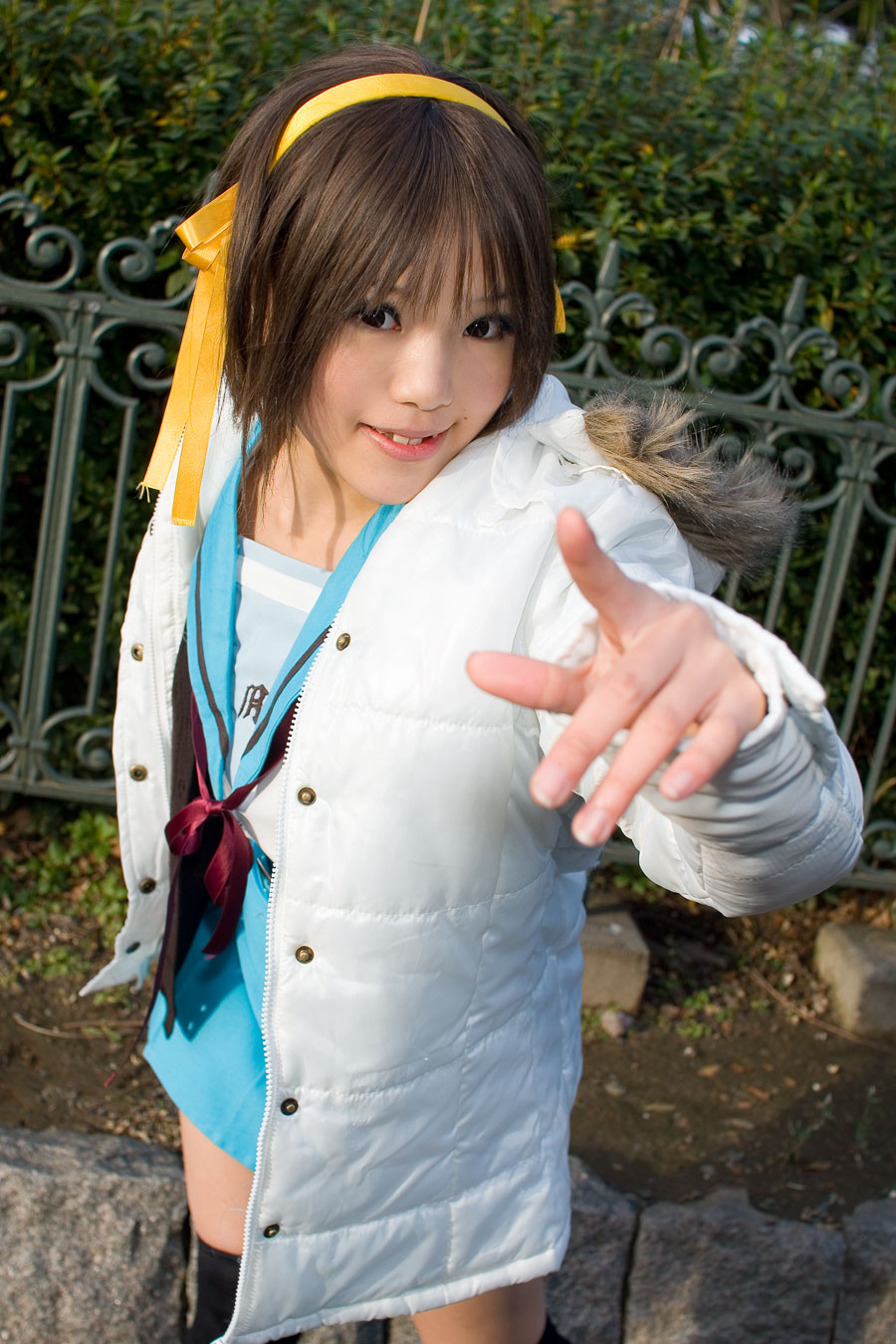 kipi-san, suzumiya haruhi, suzumiya haruhi no yuuutsu, highres, photo (medium), 1girl, asian, brown eyes, brown hair, cardigan, coat, cosplay, dutch angle, female focus, hair ribbon, hairband, looking at viewer, outdoors, pointing, pointing at viewer, ribbon, school uniform, serafuku, smile, solo, suzumiya haruhi (cosplay), thighhighs
