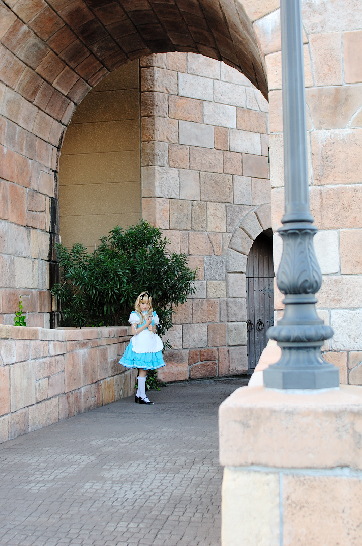 kipi-san, alice (alice in wonderland), alice's adventures in wonderland, photo (medium), 1girl, alice (alice in wonderland) (cosplay), apron, asian, blonde hair, breasts, cosplay, female focus, hair ribbon, long hair, looking at viewer, outdoors, petite, ribbon, small breasts, socks, solo