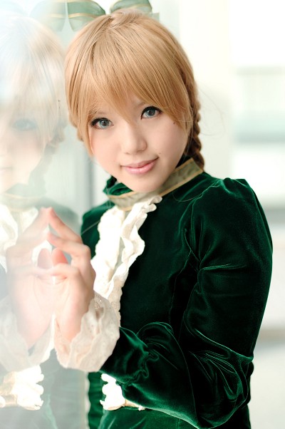 kipi-san, maki saori (swk), smash wo kimero!, photo (medium), 1girl, against glass, asian, blonde hair, blue eyes, braid, color contacts, cosplay, dress, female focus, green dress, indoors, looking at viewer, maki saori (swk) (cosplay), mole, reflection, solo, twin braids, velvet dress