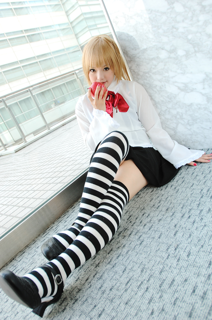 kipi-san, amane misa, death note, photo (medium), 1girl, amane misa (cosplay), apple, asian, blonde hair, breasts, cosplay, cross, cross necklace, dutch angle, female focus, food, fruit, indoors, jewelry, looking at viewer, miniskirt, mole, necklace, skirt, small breasts, solo, striped clothes, striped thighhighs, thighhighs, zettai ryouiki