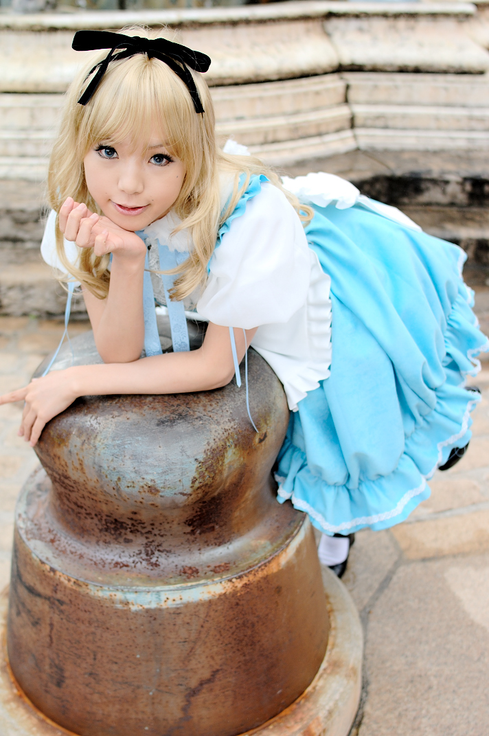 kipi-san, alice (alice in wonderland), alice's adventures in wonderland, photo (medium), 1girl, alice (alice in wonderland) (cosplay), asian, bent over, blue eyes, breasts, color contacts, cosplay, female focus, leaning forward, long hair, looking at viewer, mole, outdoors, petite, small breasts, solo
