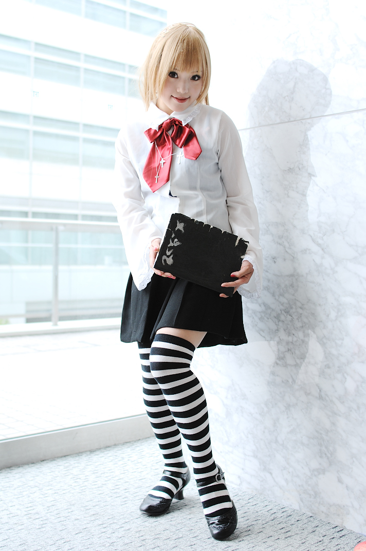 kipi-san, amane misa, death note, photo (medium), 1girl, amane misa (cosplay), asian, blonde hair, breasts, cosplay, cross, cross necklace, death note (object), female focus, indoors, jewelry, looking at viewer, miniskirt, mole, necklace, skirt, small breasts, solo, striped clothes, striped thighhighs, thighhighs