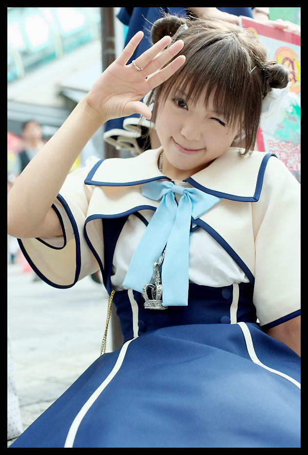 kipi-san, acasius boarding school, photo (medium), 1girl, asian, brown hair, cosplay, double bun, female focus, hair bun, looking at viewer, mole, one eye closed, outdoors, school uniform, short hair, solo, wink