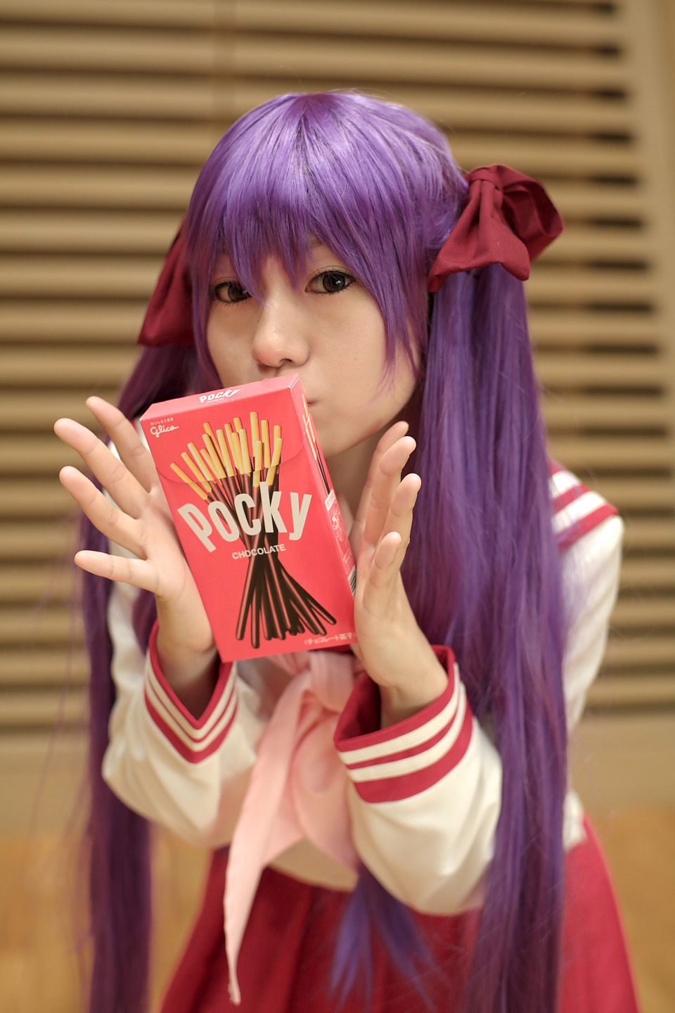 naito, hiiragi kagami, lucky star, highres, photo (medium), cosplay, hair ribbon, pocky, purple hair, ribbon, sailor, school uniform, serafuku, socks, twintails