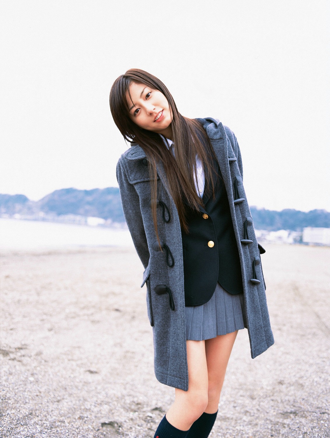 sugimoto yumi, highres, photo (medium), 1girl, asian, beach, blazer, brown hair, cardigan, coat, cosplay, dutch angle, female focus, jacket, kneehighs, long hair, looking at viewer, miniskirt, outdoors, pleated skirt, school uniform, skirt, socks, solo