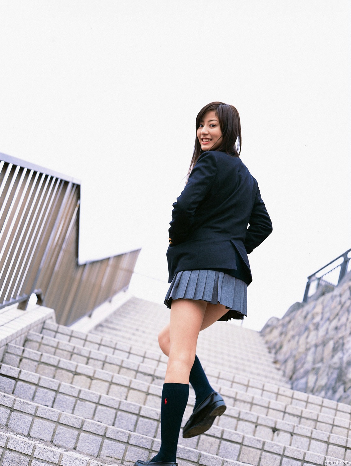 sugimoto yumi, highres, photo (medium), 1girl, asian, blazer, brown hair, cardigan, cosplay, dutch angle, female focus, jacket, kneehighs, long hair, looking at viewer, looking back, miniskirt, outdoors, pleated skirt, school uniform, skirt, socks, solo