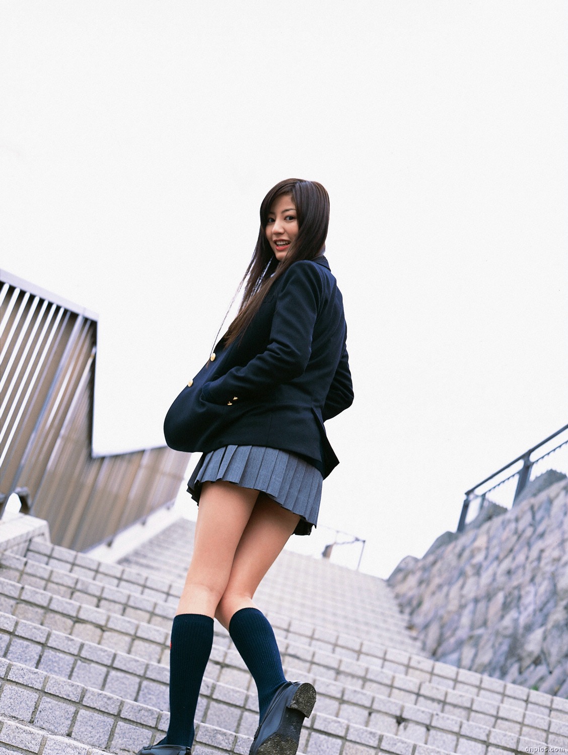 sugimoto yumi, highres, photo (medium), 1girl, asian, blazer, brown hair, cardigan, cosplay, dutch angle, female focus, jacket, kneehighs, long hair, looking at viewer, looking back, miniskirt, outdoors, pleated skirt, school uniform, skirt, socks, solo