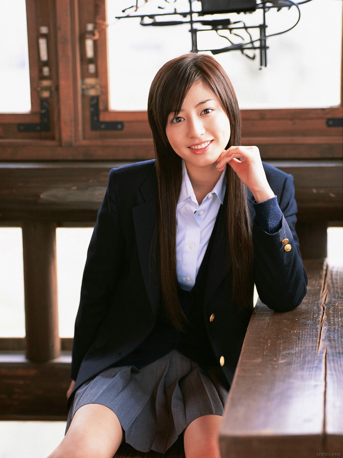 sugimoto yumi, highres, photo (medium), 1girl, asian, blazer, brown hair, cardigan, cosplay, female focus, indoors, jacket, long hair, looking at viewer, miniskirt, pleated skirt, school uniform, sitting, skirt, smile, solo