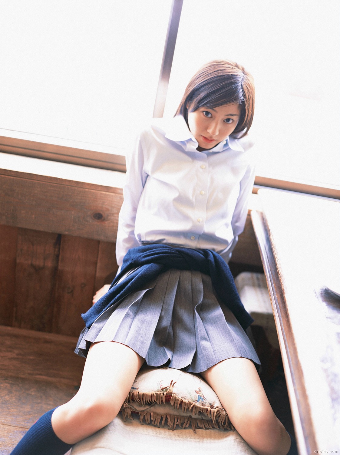 sugimoto yumi, highres, photo (medium), 1girl, asian, brown hair, cardigan, cosplay, dutch angle, female focus, indoors, kneehighs, long hair, looking at viewer, miniskirt, pleated skirt, school uniform, sitting, skirt, socks, solo