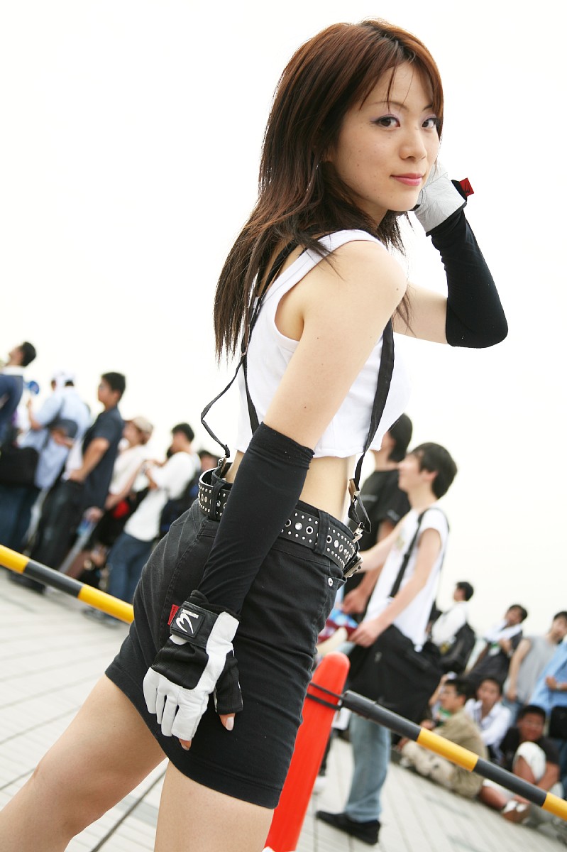 shouka, tifa lockhart, final fantasy, final fantasy vii, highres, photo (medium), 1girl, asian, cloudy sky, cosplay, crop top, crop top overhang, dutch angle, fingerless gloves, gloves, looking at viewer, looking back, midriff, miniskirt, multiple boys, outdoors, skirt, smile, solo focus, suspenders, tank top