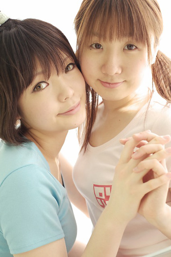 miasa, namada, photo (medium), translated, 2girls, asian, black hair, brown eyes, brown hair, clothes writing, color contacts, interlocked fingers, long hair, looking at viewer, multiple girls, shirt, short hair, simple background, t-shirt, twintails, white background