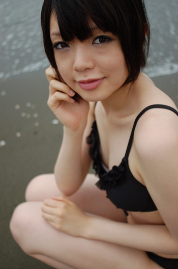 namada, photo (medium), tagme, 1girl, asian, beach, bikini, black bikini, black hair, breasts, female focus, looking at viewer, outdoors, short hair, small breasts, solo, squatting, swimsuit