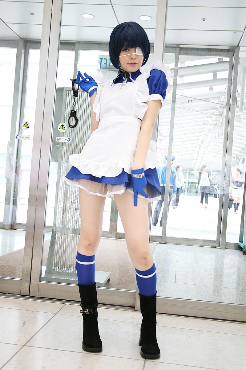 namada, ryomou shimei, ikkitousen, black footwear, highres, photo (medium), 1girl, apron, asian, blue eyes, blue gloves, blue hair, blue socks, boots, collar, color contacts, contrapposto, cosplay, cross, cuffs, dutch angle, eyepatch, gloves, handcuffs, high heels, indoors, kneehighs, looking at viewer, maid, maid apron, puffy short sleeves, puffy sleeves, ryomou shimei (cosplay), short sleeves, socks, solo focus, standing