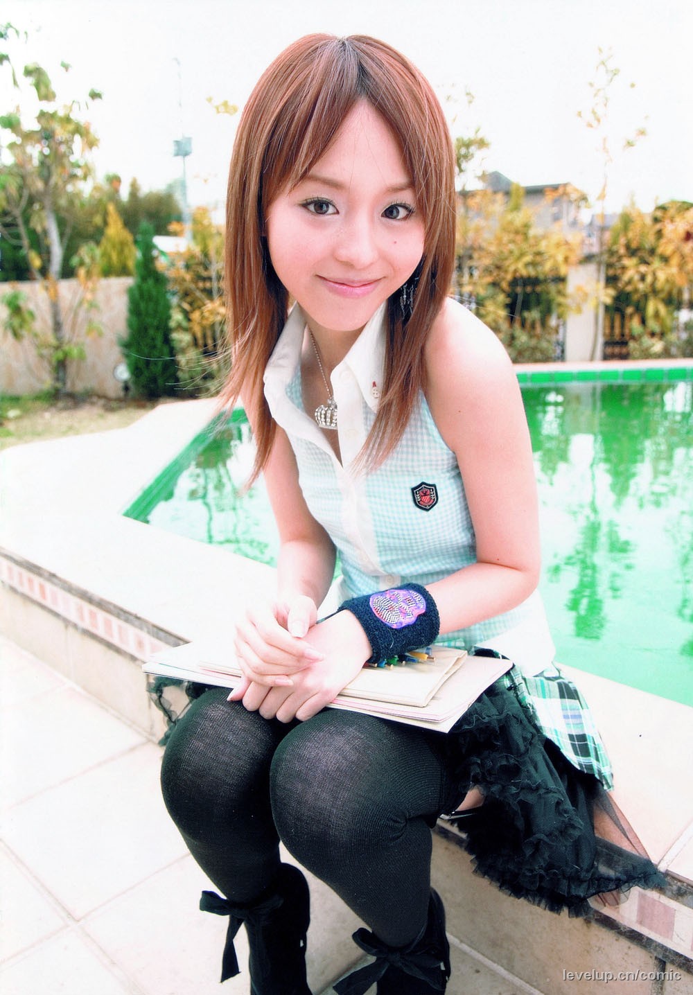 hirano aya, highres, photo (medium), 1girl, female focus, frills, happy, looking at viewer, outdoors, pleated skirt, pool, shirt, skirt, sleeveless, sleeveless shirt, smile, solo, thighhighs