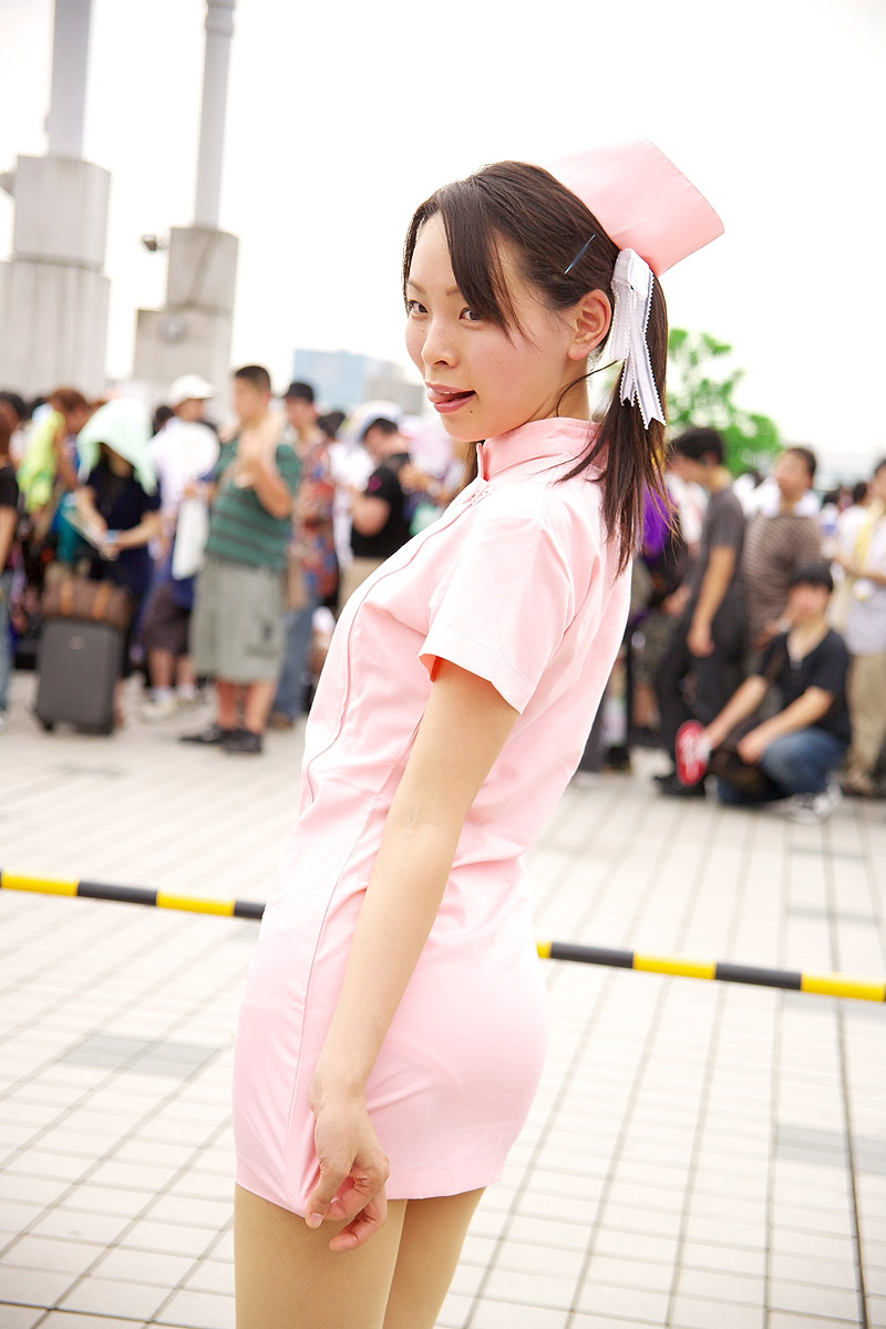 yuu (455687), kodama hikaru, yakin byoutou, highres, photo (medium), 1girl, 6+boys, asian, blurry, bow, breasts, brown hair, cosplay, cowboy shot, depth of field, hair bow, hair ornament, hairclip, hat, legs together, looking back, mole, mole under mouth, multiple boys, nurse, nurse cap, pantylines, small breasts, solo focus, standing, twintails