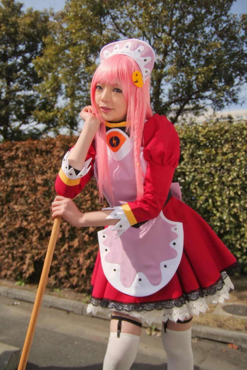 namada, nono (top wo nerae 2!), top wo nerae! (series), top wo nerae 2!, highres, photo (medium), 1girl, apron, asian, blurry, breasts, broom, cosplay, depth of field, dress, female focus, garter straps, head rest, hedge, leaning forward, light smile, looking at viewer, maid, maid apron, makeup, mascara, outdoors, parking lot, pink hair, puffy sleeves, short dress, sidelocks, small breasts, solo, standing, thighhighs, tree, white thighhighs, zettai ryouiki